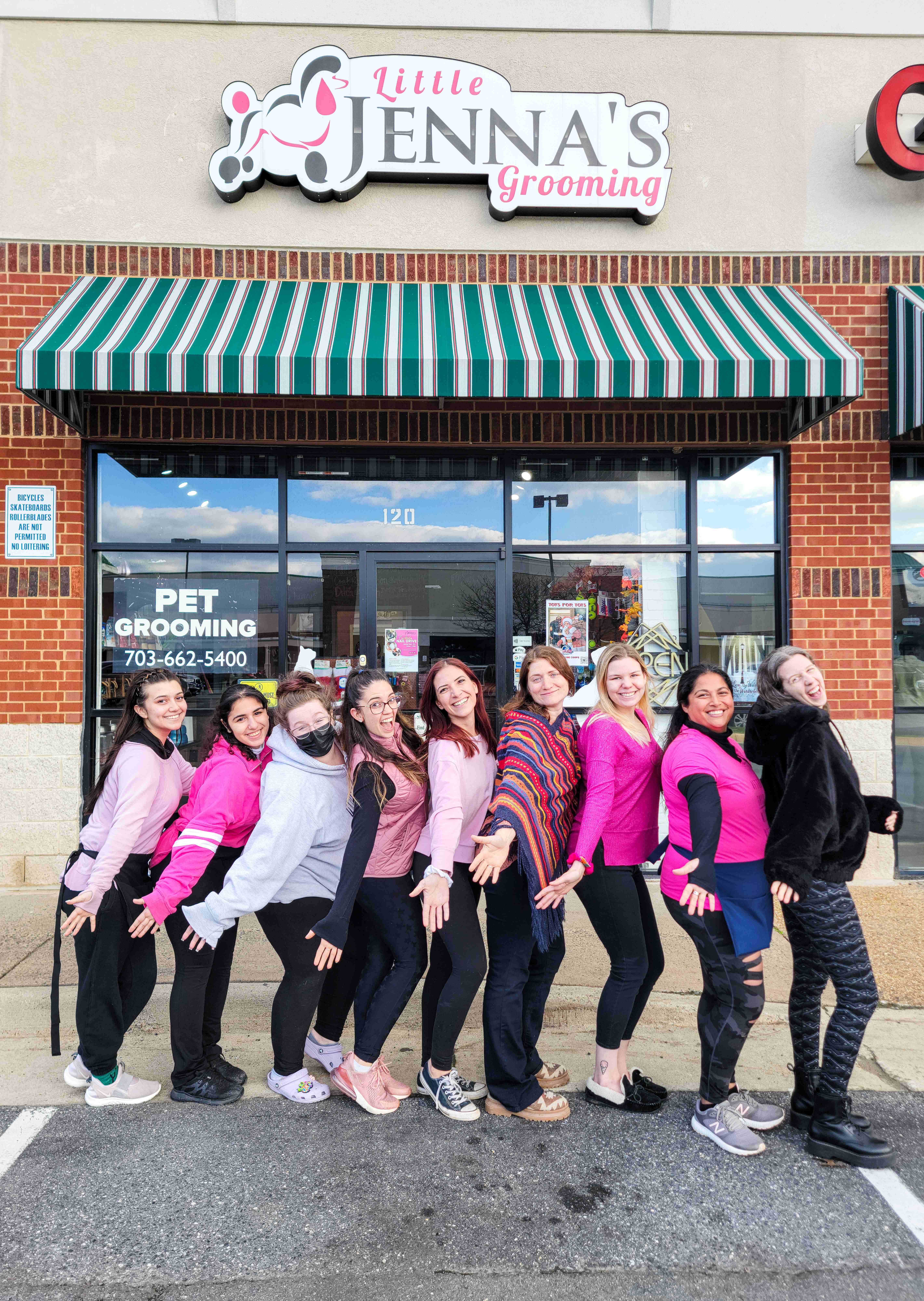 The Little Jenna's Grooming team posing together in front of the salon storefront